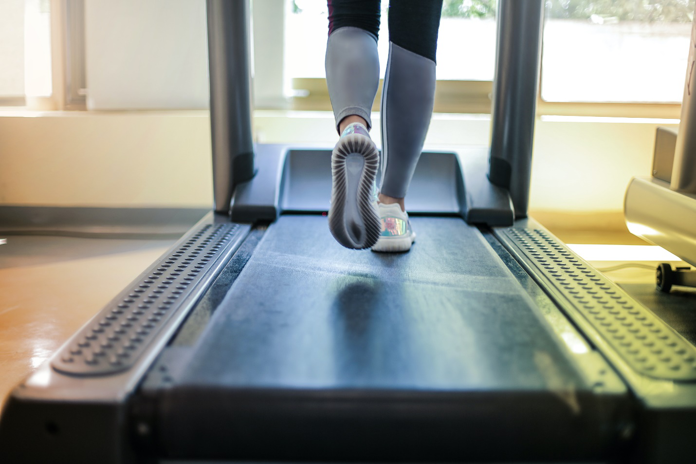 A pair of feet is seen running on a treadmill