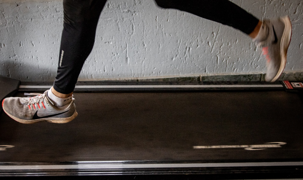 A pair of feet seen jogging on a treadmill